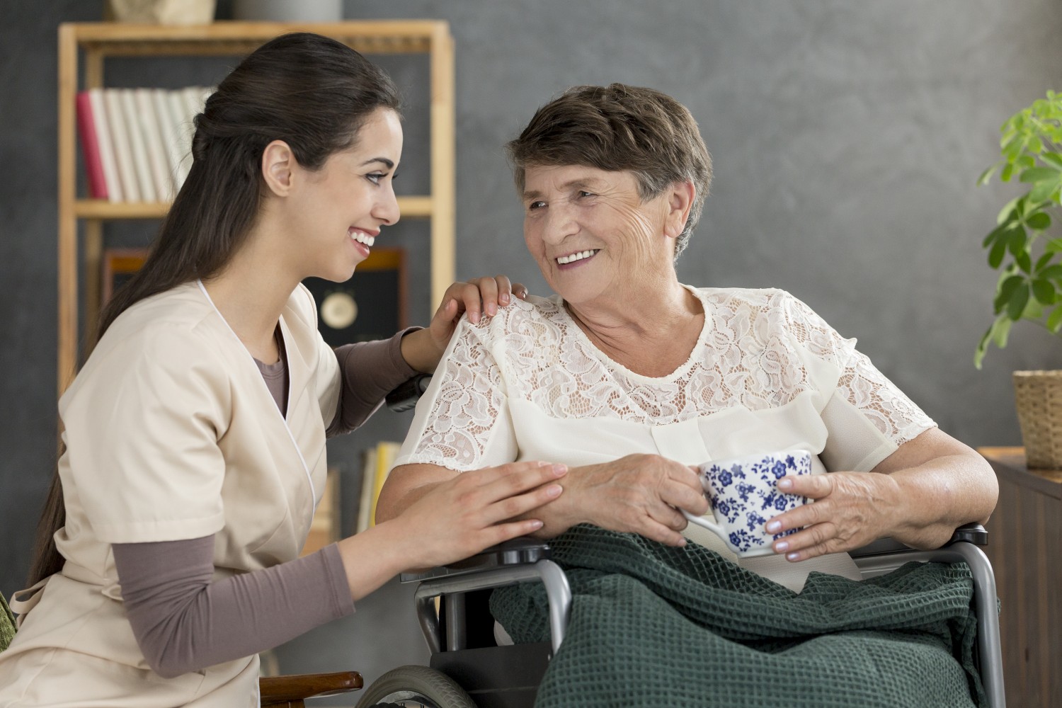 A compassionate caregiver offering comfort and reassurance to an elderly woman in the evening
