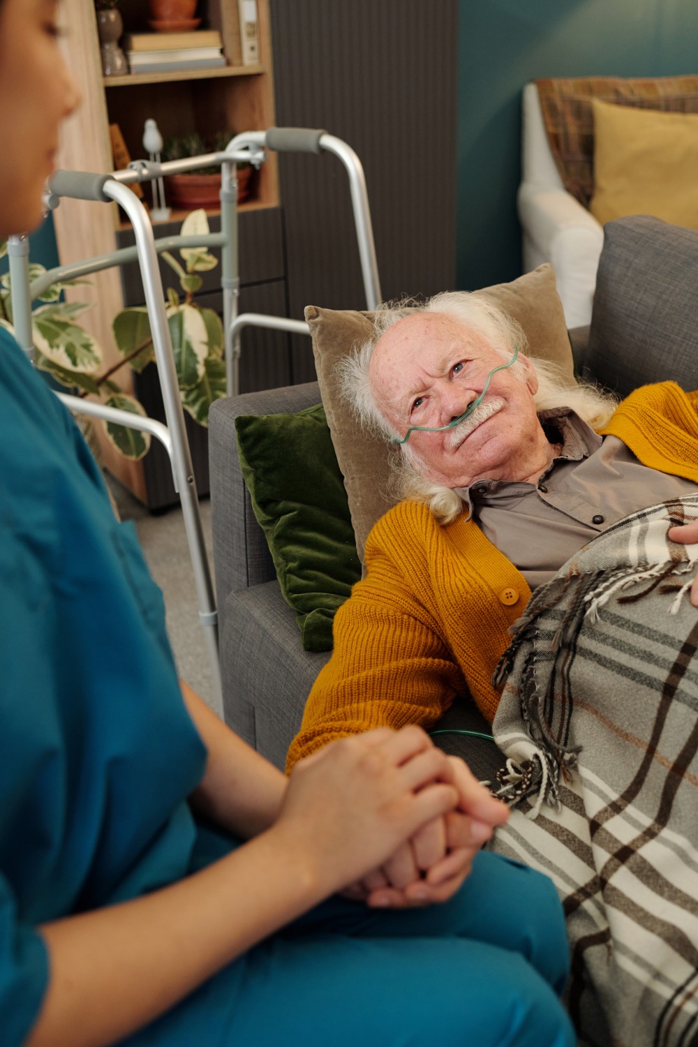 An elderly man relaxing comfortably at home with the support of a caregiver