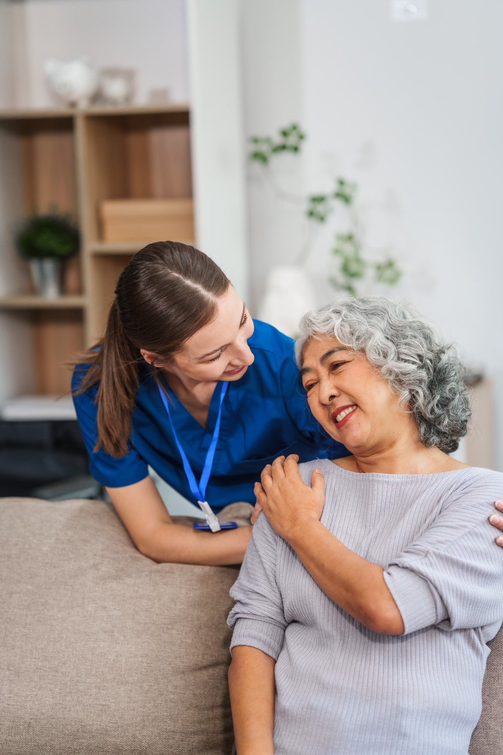 A smiling senior woman at home with her live-in caregiver in a warm, comfortable setting
